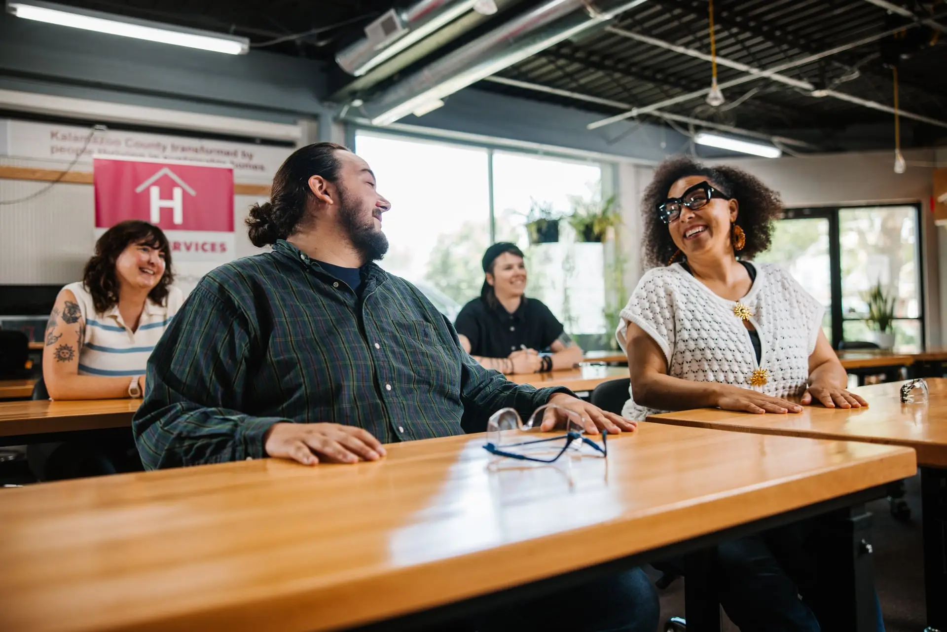 Man and woman sitting at a desk and smiling at eachother.