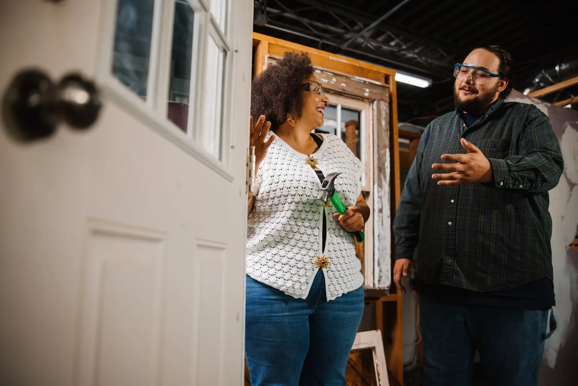 A man and woman standing in front of a white door.