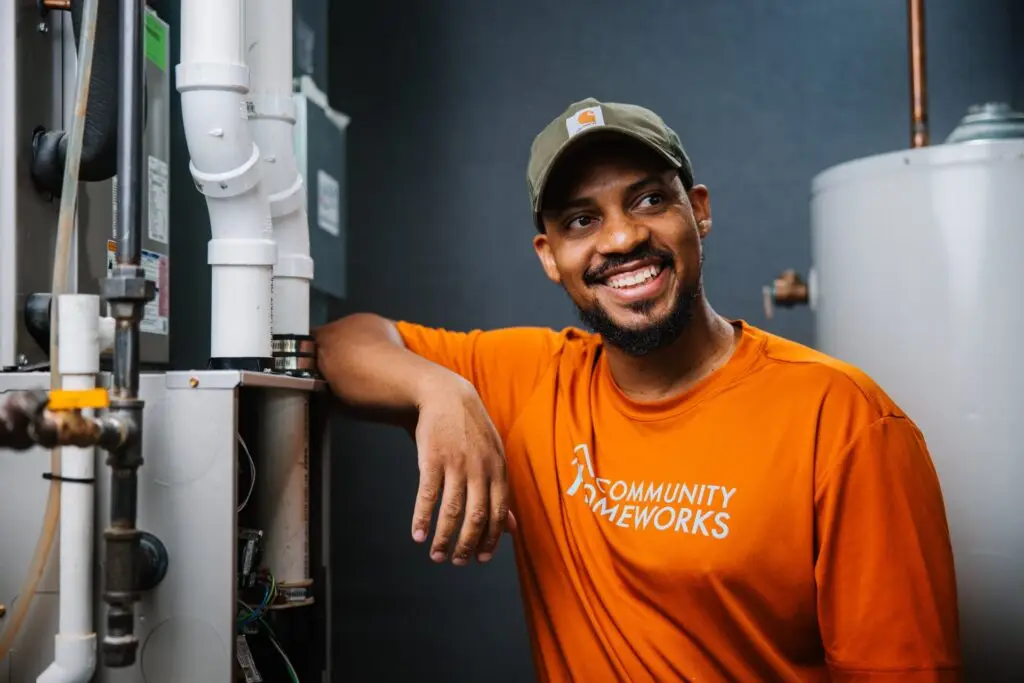 Man in a hat with an orange Community Homeworks shirt.