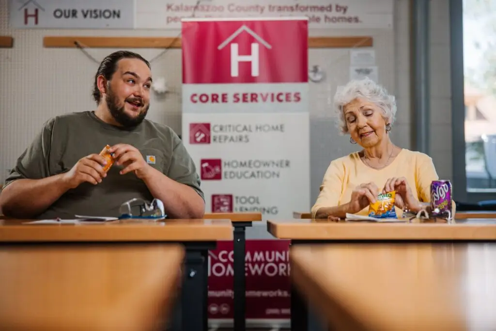 Man and woman sitting next to each other at desks during a workshop.
