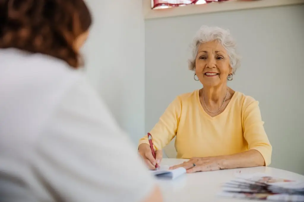 A woman sitting down with a pen and paper.